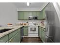 Renovated kitchen with granite countertops and green cabinets at 11 Stone Village, Durham, NC 27704