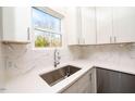 White kitchen cabinets, marble backsplash, and stainless steel sink at 1127 Elmo St, Durham, NC 27701