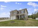 Two-story house with gray siding, white garage door, and landscaped lawn at 148 Cumberland Dr, Sanford, NC 27332
