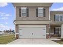 White double-car garage with stone accents at 148 Cumberland Dr, Sanford, NC 27332