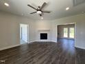 Spacious living room featuring wood floors, a ceiling fan, and a fireplace with a wooden mantle at 286 Longbow Dr, Middlesex, NC 27557