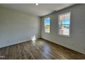 Bright bedroom with wood-look flooring, neutral walls, and well-lit by two windows at 302 Longbow Dr, Middlesex, NC 27557