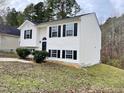 Side view of a white two-story house with black windows and landscaping at 311 Gladstone Dr, Durham, NC 27703