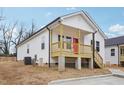 Single Gathering home boasts a charming front porch and white siding, complete with well-maintained landscaping at 825 Graham St, Burlington, NC 27217
