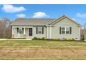 Single-story house with gray siding, a porch, and a driveway at 120 Starry Sky Dr, Benson, NC 27504