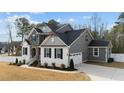 Side view of a home with a brick and gray siding exterior, plus a two-car garage and paved driveway at 128 S Clearbrook Ct, Angier, NC 27501