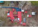 Overhead view of home with a red metal roof, outbuildings, landscaping, driveway, and surrounding bare trees at 253 Ronald Tharrington Rd, Louisburg, NC 27549