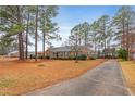 Side view of brick home showcasing driveway and landscape at 302 S Pine St, Benson, NC 27504