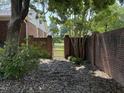 The backyard features a brick fence with an access gate surrounded by lush landscaping at 307 Westfield Dr, Dunn, NC 28334