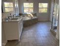 Bright bathroom with a double vanity, large soaking tub, and tiled floors at 307 Westfield Dr, Dunn, NC 28334