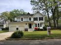 Inviting two-story home with white siding, a two-car garage, and a well-maintained front lawn with 'For Sale' sign at 4300 Hickory Ridge Dr, Raleigh, NC 27609