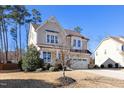 Two-story house with beige siding, stone accents, and a two-car garage at 4538 Brighton Ridge Dr, Apex, NC 27539