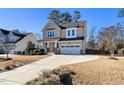Two-story house with beige siding, a large driveway, and landscaping at 4538 Brighton Ridge Dr, Apex, NC 27539