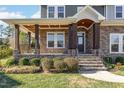 Stone and wood covered porch with steps leading to the front door at 5 Bee Hill Pl, Durham, NC 27705