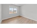 Bright bedroom with light walls, wood-look floors, and a large window at 529 Ravensworth Dr, Garner, NC 27529