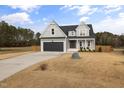 Two-story house with gray siding, dark gray garage door, and a landscaped yard at 8909 Hopkins Knob Ct, Zebulon, NC 27597