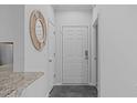 A clean, neutrally decorated entryway with a round mirror and granite countertop visible at 105 Fountain Ridge Pl, Holly Springs, NC 27540