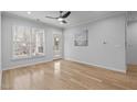 Bright living room featuring light wood floors, a ceiling fan, and ample natural light from large windows at 105 Fountain Ridge Pl, Holly Springs, NC 27540
