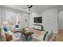 Cozy living room with hardwood floors, bright natural light, a ceiling fan, and comfortable seating arrangements at 105 Fountain Ridge Pl, Holly Springs, NC 27540