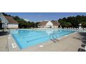 Community swimming pool featuring a large pool with lounge chairs and umbrellas for residents' enjoyment at 105 Fountain Ridge Pl, Holly Springs, NC 27540