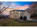 Two-story house with tan siding, red shutters, and a landscaped lawn at dusk at 1216 Magnolia Hill Rd, Garner, NC 27529