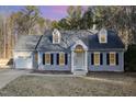 Gray house with attached garage and manicured lawn at dusk at 1702 Grand Barton Ct, Apex, NC 27502