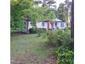 Charming white ranch home with red door and mature trees at 3259 Us 421, Lillington, NC 27546