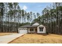 Modern farmhouse exterior, featuring a white exterior, brown accents, and a large yard at 4120 Emily Ln, Oxford, NC 27565