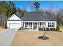 Beautiful white home featuring a welcoming front porch and well-maintained landscaping at 430 Heart Pine Dr, Wendell, NC 27591