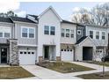 Modern townhome with gray and white exterior, attached garage, and stone accents at 45 Oatland Pl, Pittsboro, NC 27312