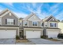 Three-story townhouses with gray siding, two-car garages, and landscaping at 5825 Humanity Ln, Raleigh, NC 27616