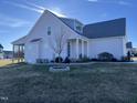 Side view showcasing a two-story house, screened porch, and landscaped yard at 60 Buttonwood Ct, Youngsville, NC 27596