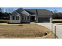 Gray siding, two-car garage, and a spacious front yard at 105 Hydrangea Ln, Benson, NC 27504