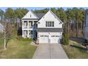 Two-story house with white siding, stone accents, and a large backyard at 1305 Magnolia Glen Circle, Wake Forest, NC 27587