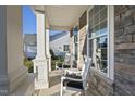 Front porch with rocking chairs and view of neighboring houses at 1305 Magnolia Glen Circle, Wake Forest, NC 27587
