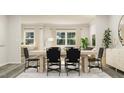 Bright dining room with a wood table and black chairs, overlooking the living room at 1848 Poe Farm Ave, Apex, NC 27502