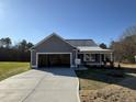 Newly built home with gray siding, a two-car garage, and a concrete driveway at 411 Magnolia Run Way, Benson, NC 27504