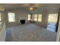 Bright living room with gray carpeting, fireplace, and ceiling fan at 411 Magnolia Run Way, Benson, NC 27504