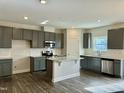 Modern kitchen with gray cabinets, granite island, and stainless steel appliances at 554 Eversden Dr, Zebulon, NC 27597