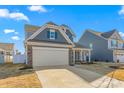 Gray house with stone accents, a two-car garage, and a white front door at 1039 Brockton Dr, Mebane, NC 27302