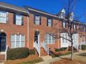 Brick front of townhome with white stairs and landscaping at 121 Lumina Pl, Holly Springs, NC 27540