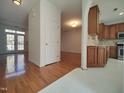 Open-concept living area with hardwood floors, white trim, and views into the kitchen with stainless appliances at 121 Lumina Pl, Holly Springs, NC 27540