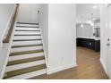 Stylish staircase leading to upper level with kitchen view at 2029 Maggie Valley Dr, Apex, NC 27502