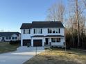 Two-story house, white siding, dark gray garage doors, and a partially visible driveway at 228 Mahogany Way, Four Oaks, NC 27524