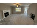 Living room with gray walls, a fireplace, and a view of the kitchen at 228 Mahogany Way, Four Oaks, NC 27524