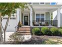 Inviting front porch with seating area and brick steps at 296 Two Creeks Lp, Chapel Hill, NC 27517