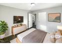 Virtually staged bedroom with wood-look floors, dresser, and large TV at 708 N Allen Rd, Wake Forest, NC 27587