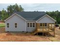 View of the back of the home with gray siding and a wooden deck with black railings at 95 Purslane Dr, Franklinton, NC 27525
