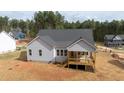 Back view of a gray siding house with a wooden porch and stairs leading down to the yard at 95 Purslane Dr, Franklinton, NC 27525