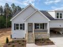 Charming single-Gathering home featuring stone accents, gray siding, attached garage, and a welcoming front porch at 95 Purslane Dr, Franklinton, NC 27525